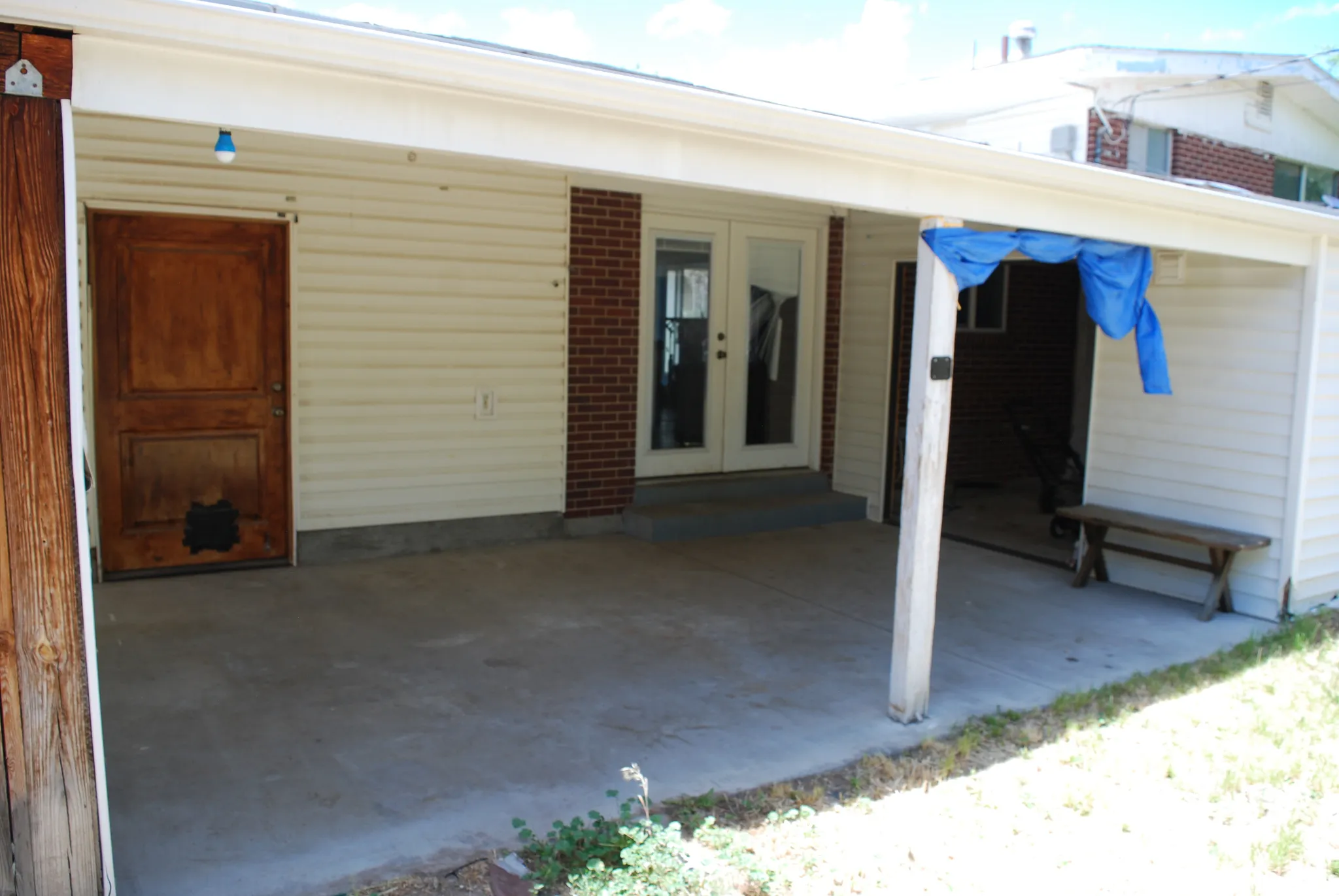 Covered patio featuring concrete flooring and a white vinyl siding exterior