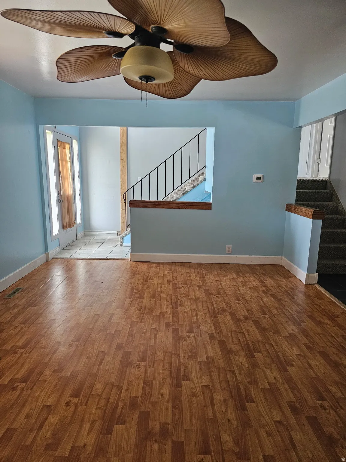 Wood-finish flooring throughout the main living area, complemented by light blue wall tones