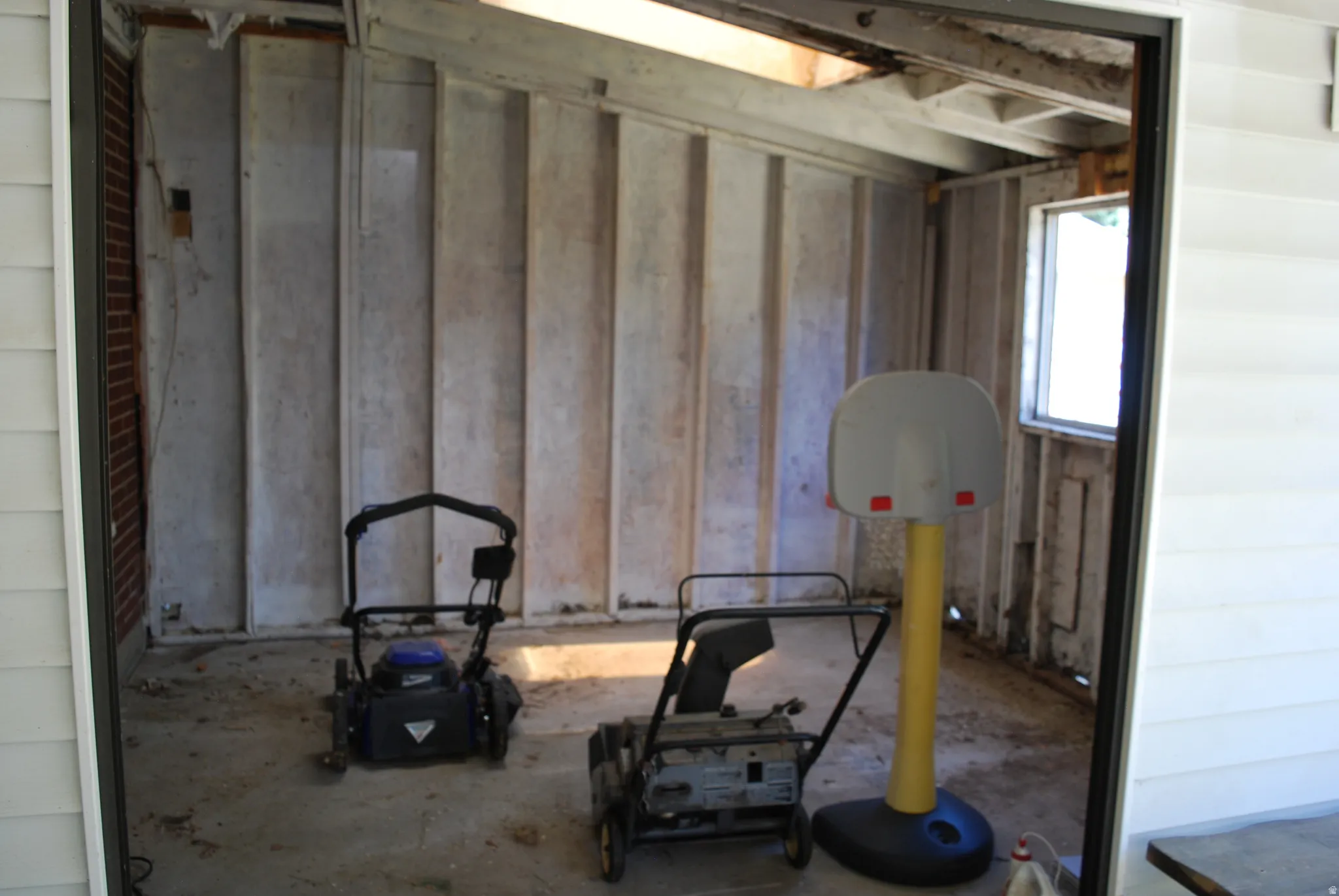 Unfinished interior space featuring exposed ceiling joists and a single window
