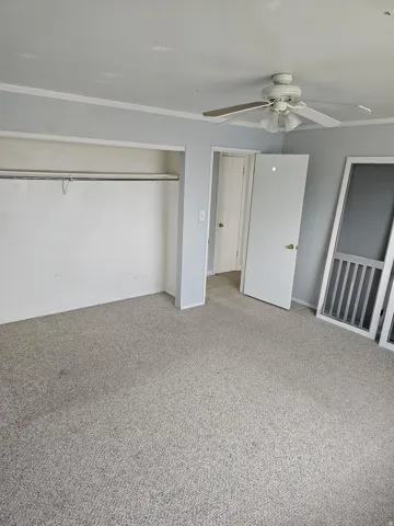 Light gray wall paint, white trim, and light gray carpeting define this interior space