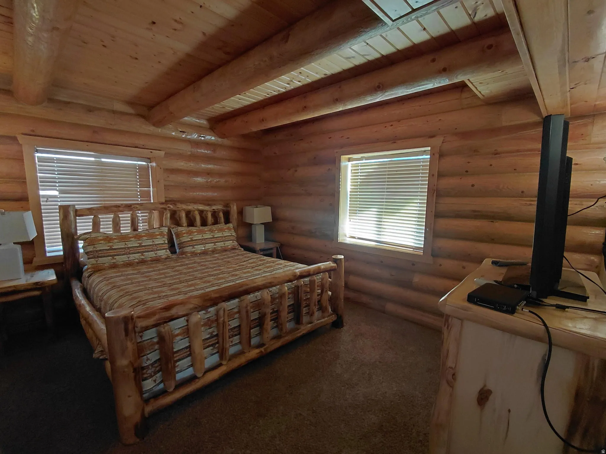 Room featuring log wall construction and exposed wood beams