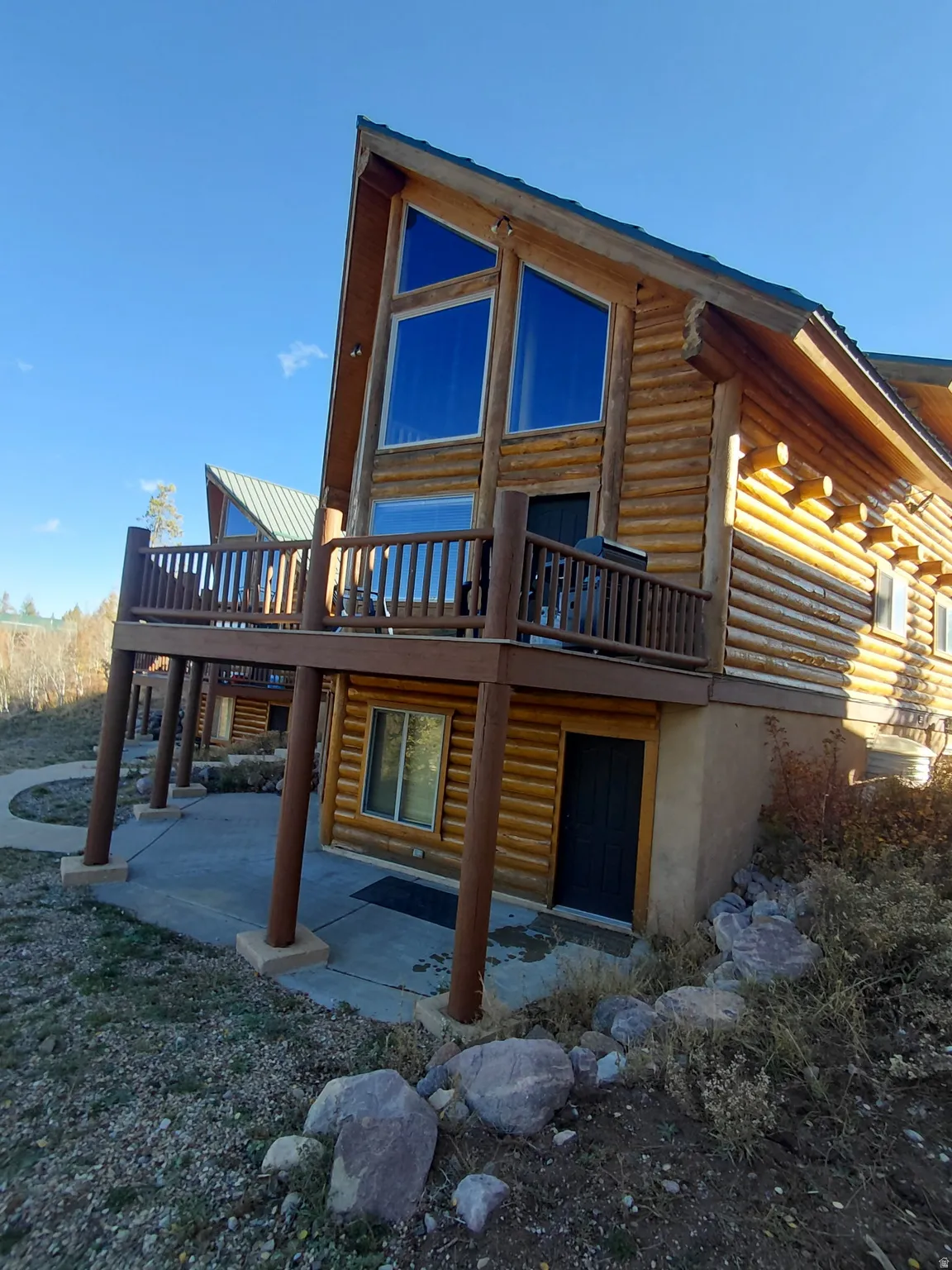 Log home exterior featuring a prominent A-frame architectural style and log siding