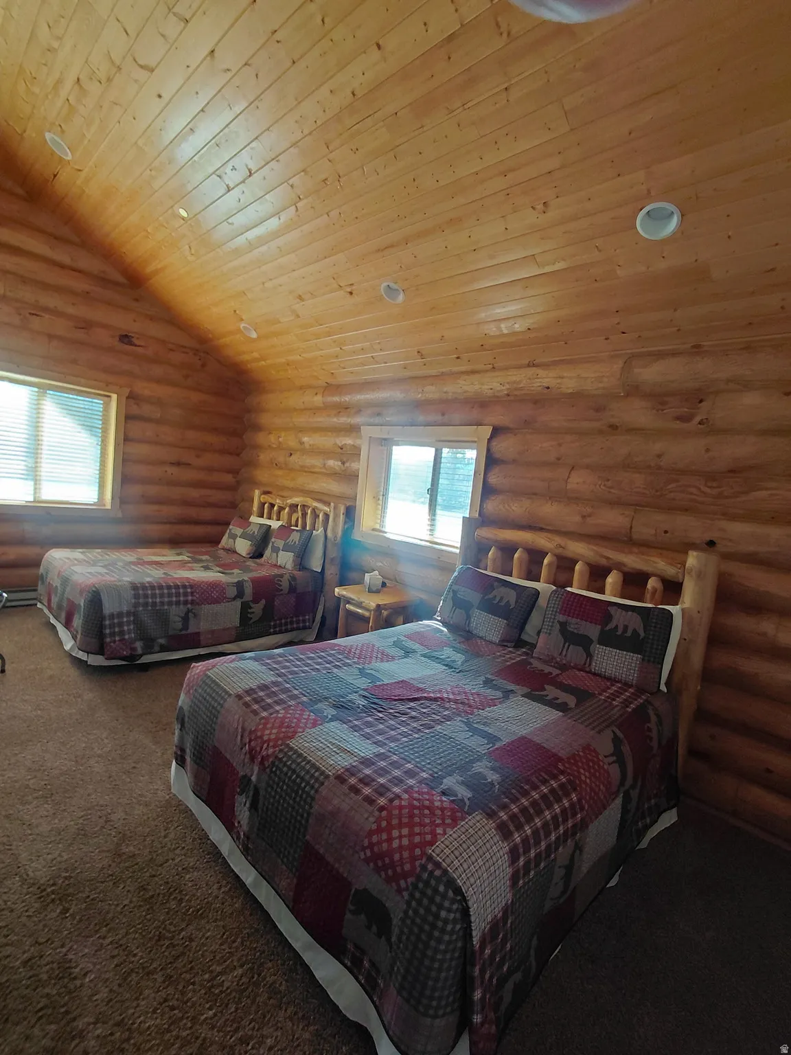 Room featuring wood-plank walls and a sloped wood-plank ceiling with recessed lighting