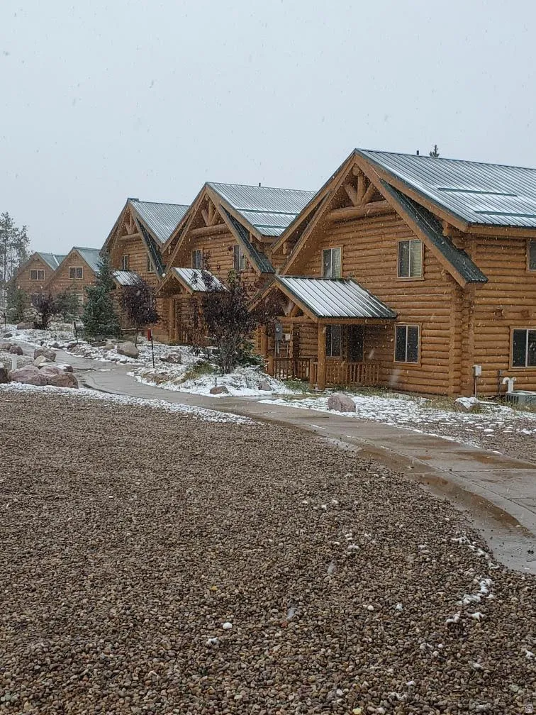 Log-sided structures with gabled roofs and covered entryways