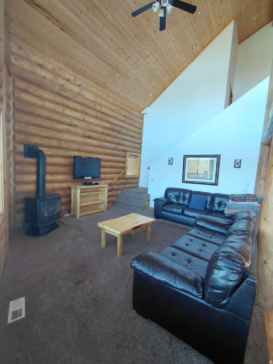 Vaulted wood-plank ceilings feature a ceiling fan and recessed lighting
