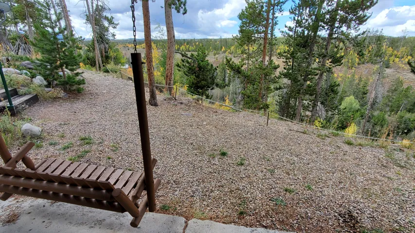 Terraced outdoor area featuring natural stone steps, gravel ground cover, and mature pine trees