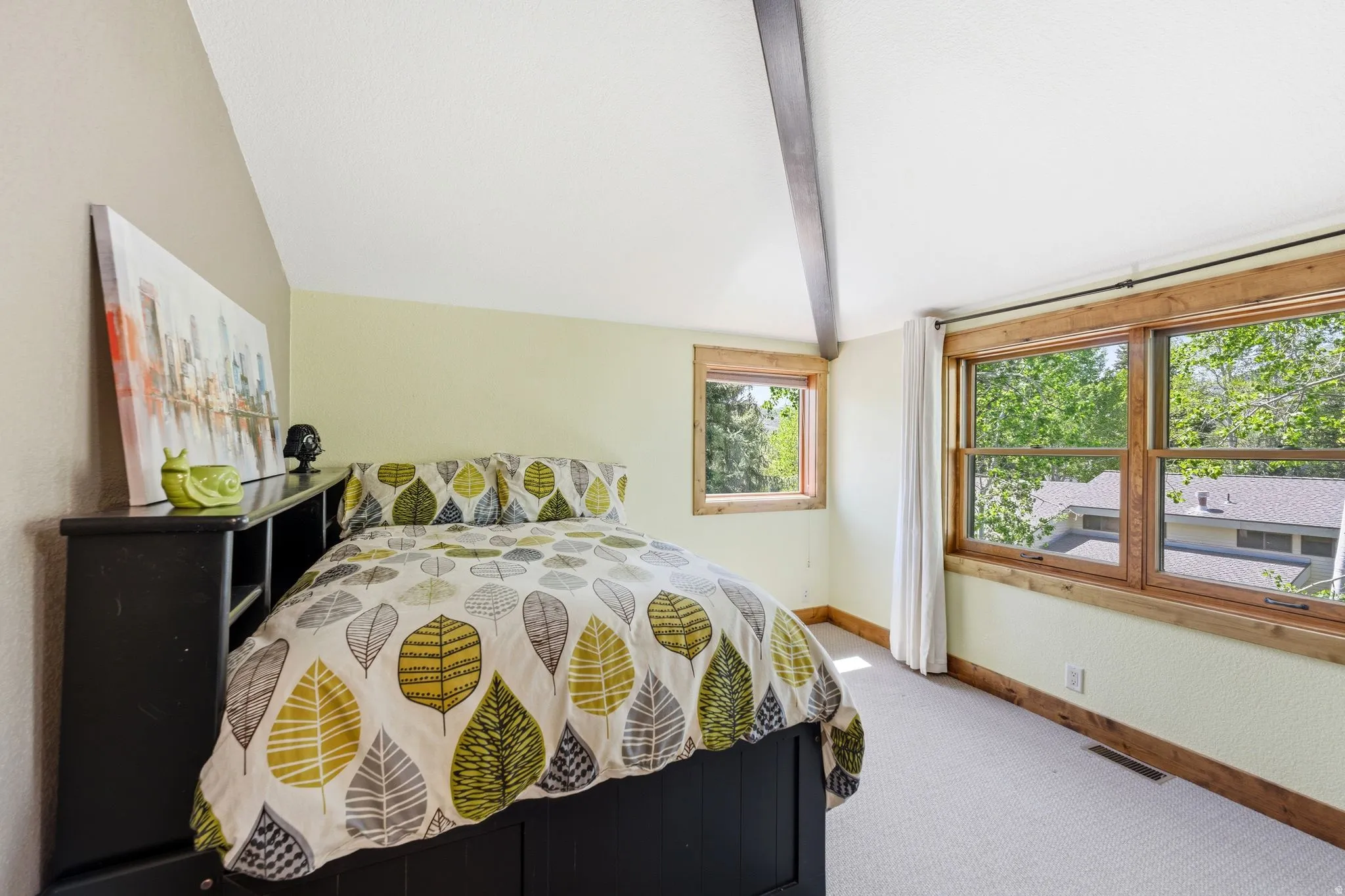 Bedroom featuring natural wood-framed windows, a sloped ceiling, and wood-finish ceiling beams