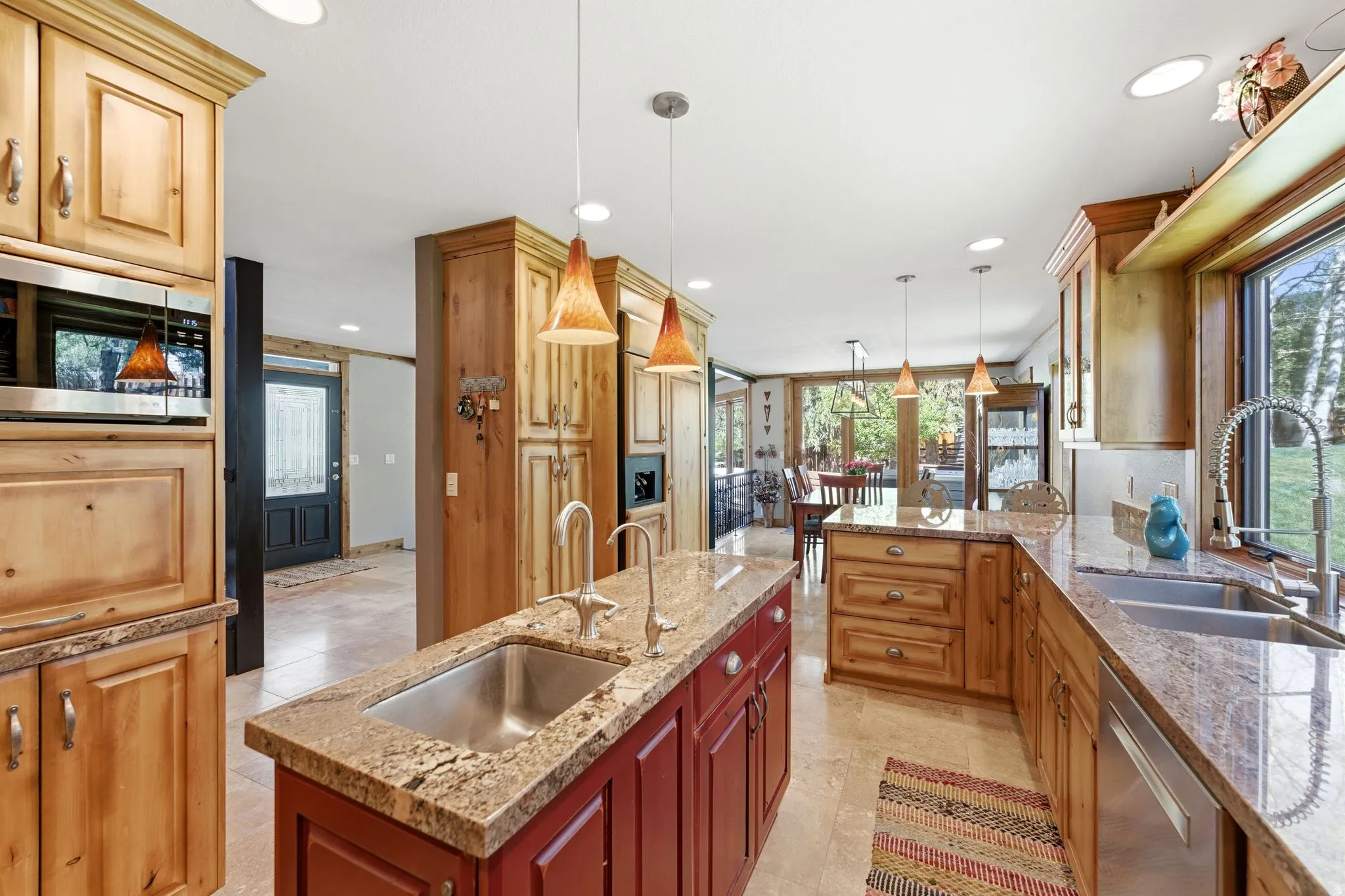 Kitchen featuring a central island with an undermount sink, granite countertops, wood cabinetry, and recessed lighting