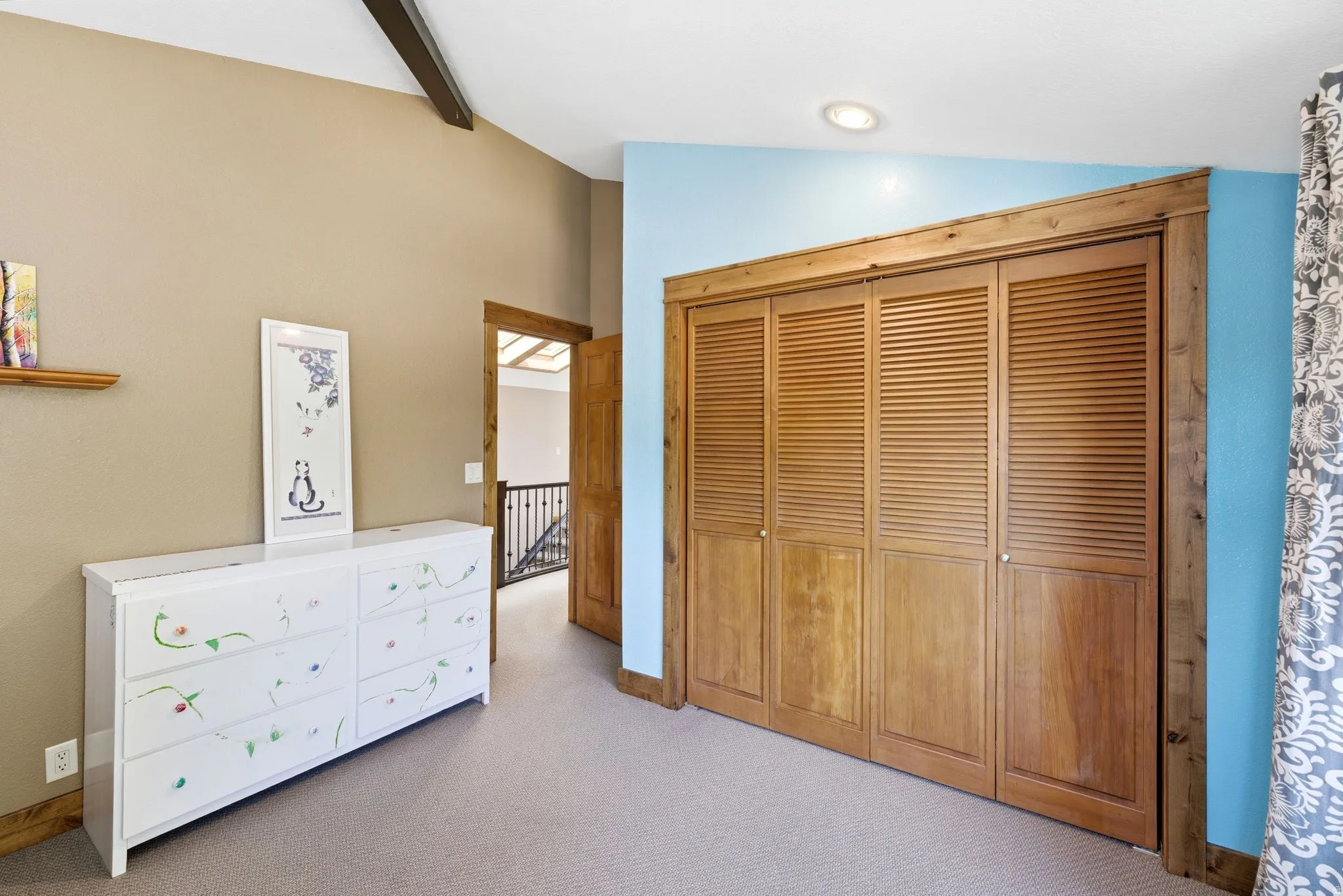 Wood-finish bi-fold closet doors featuring louvered panels and natural wood trim