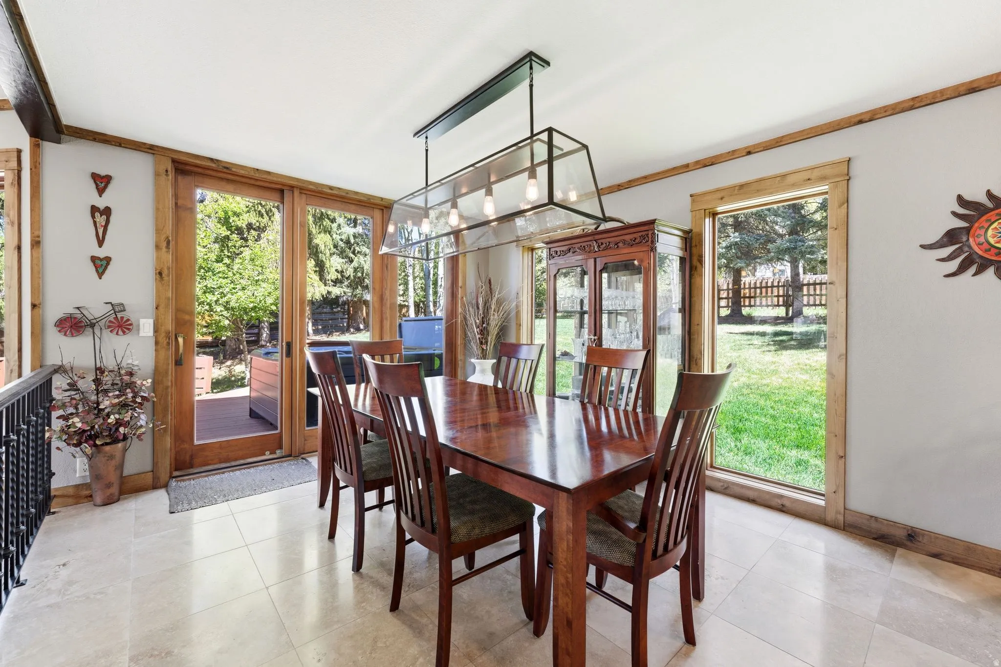 Bright dining area featuring large format tile flooring and extensive natural wood trim