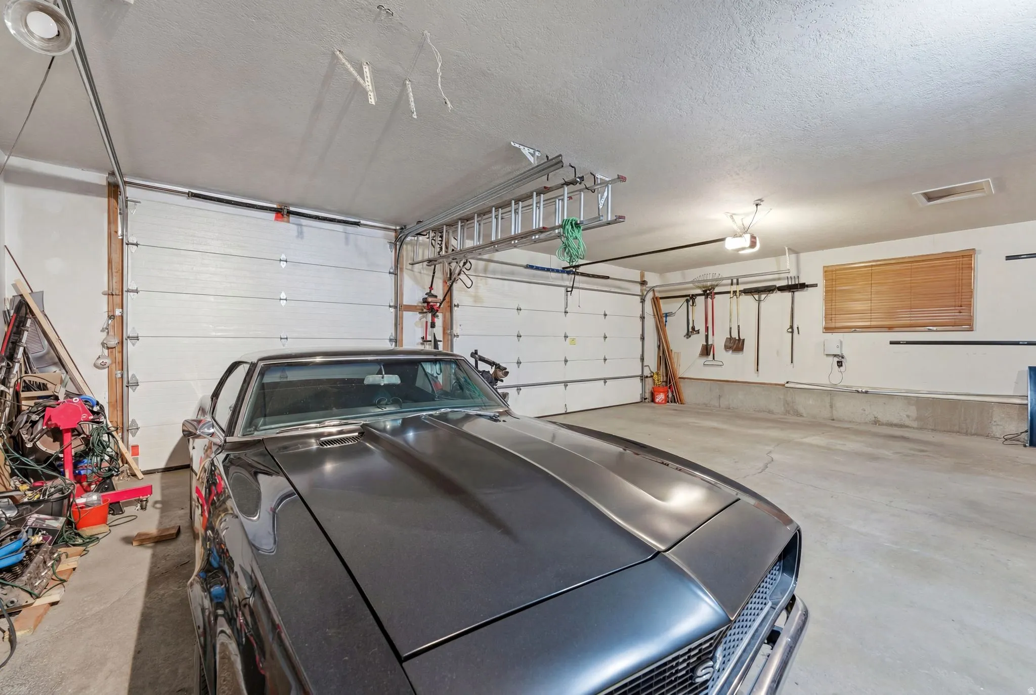 Spacious garage featuring concrete flooring and two overhead garage doors