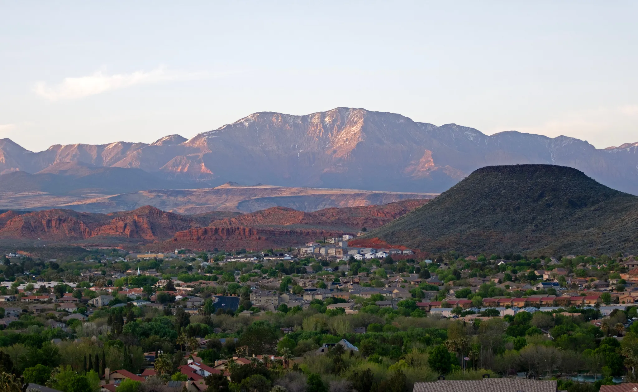 Expansive mountainous terrain with snow-capped peaks and red rock formations
