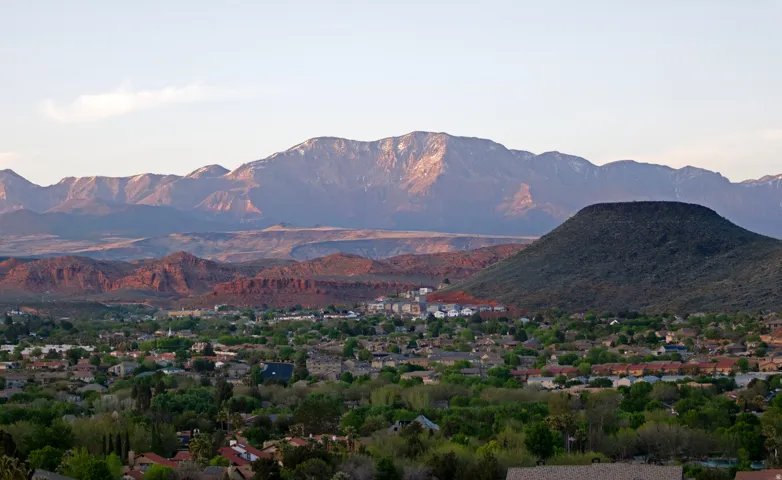 Expansive mountainous terrain with snow-capped peaks and red rock formations