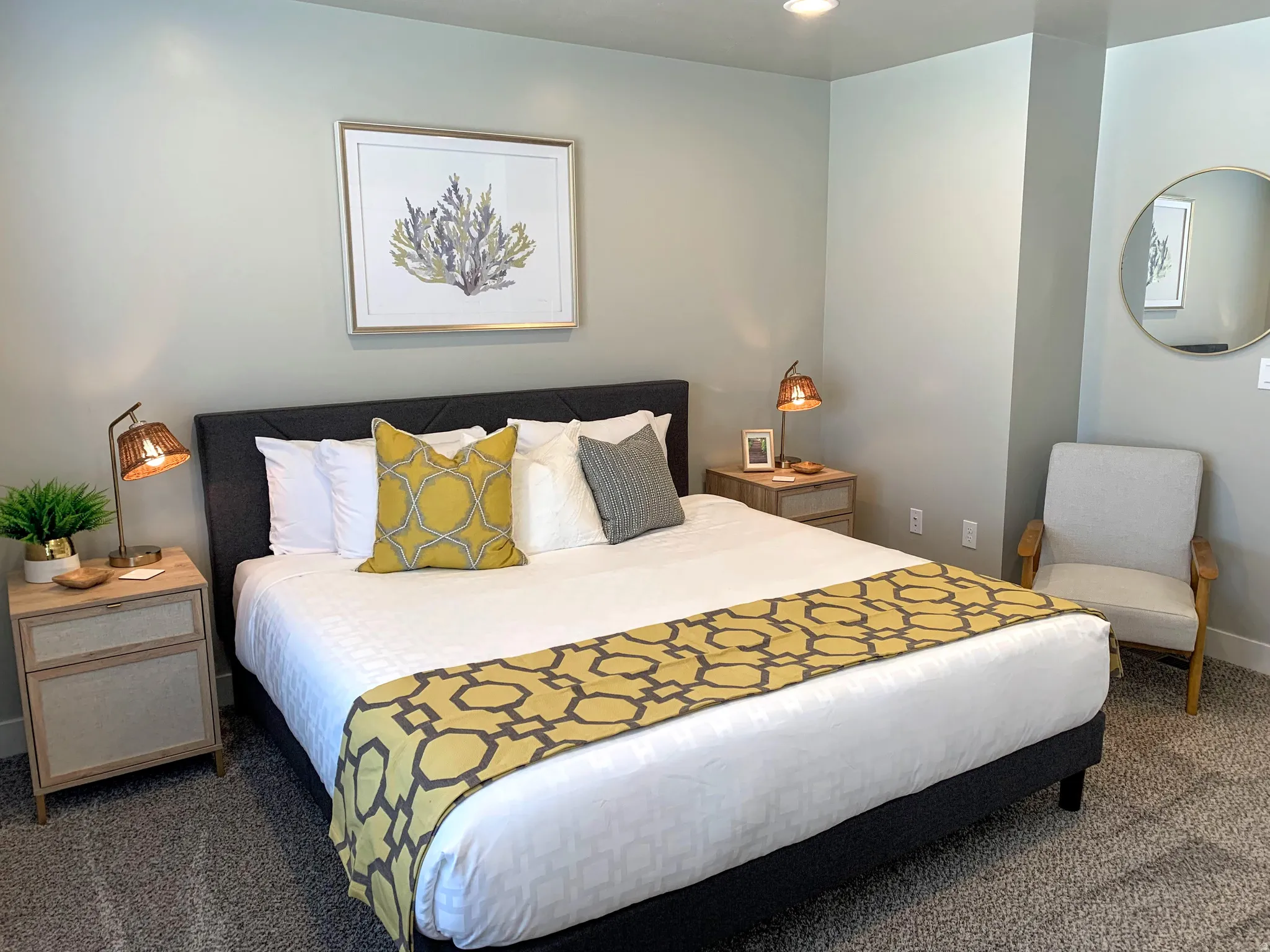 Carpeted sleeping area featuring a dark upholstered headboard, recessed lighting, and light gray wall paint