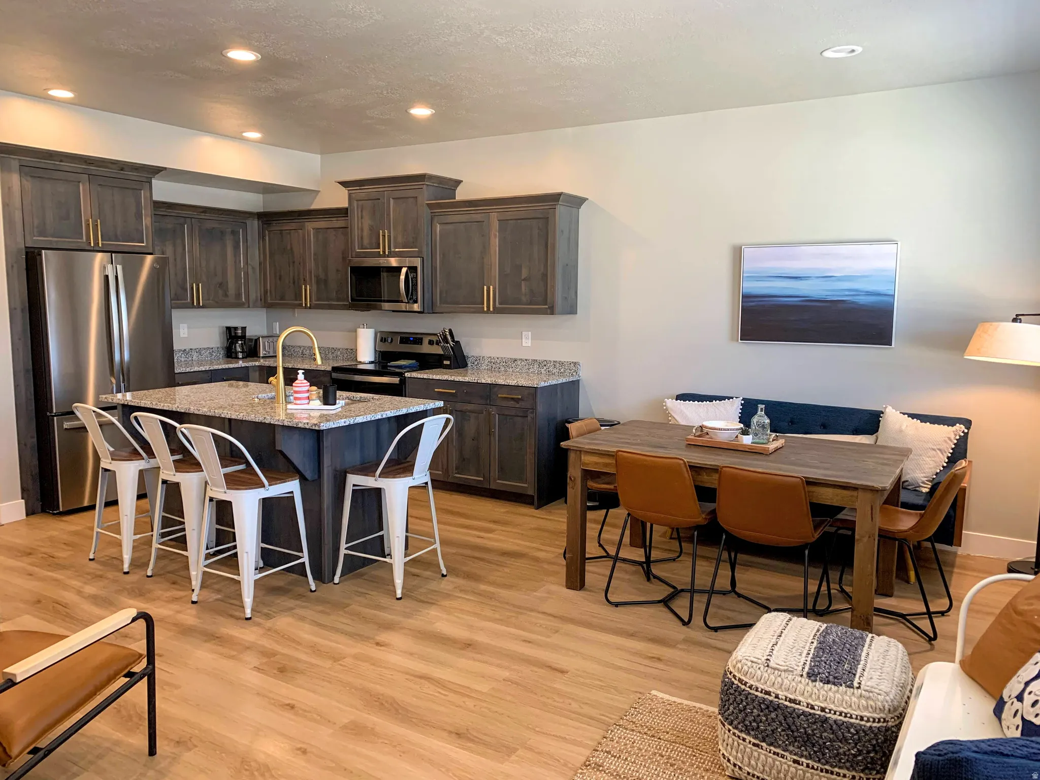 Open-concept kitchen and dining area featuring wood-finish flooring