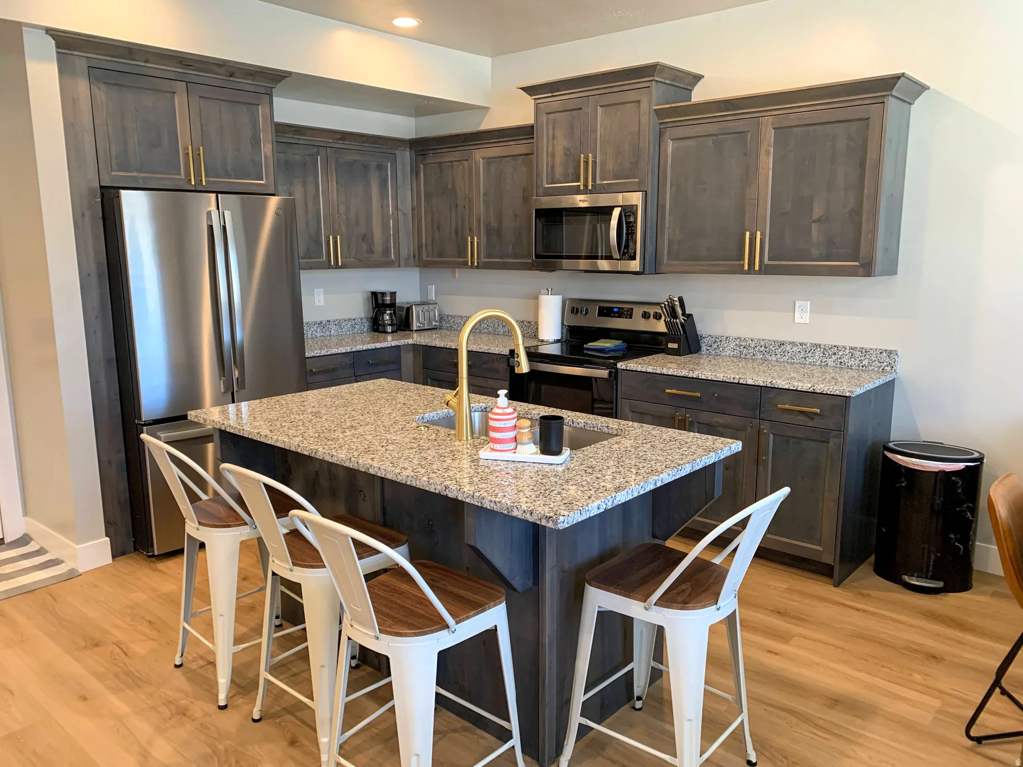 Contemporary kitchen featuring wood-finish flooring and a central island with seating