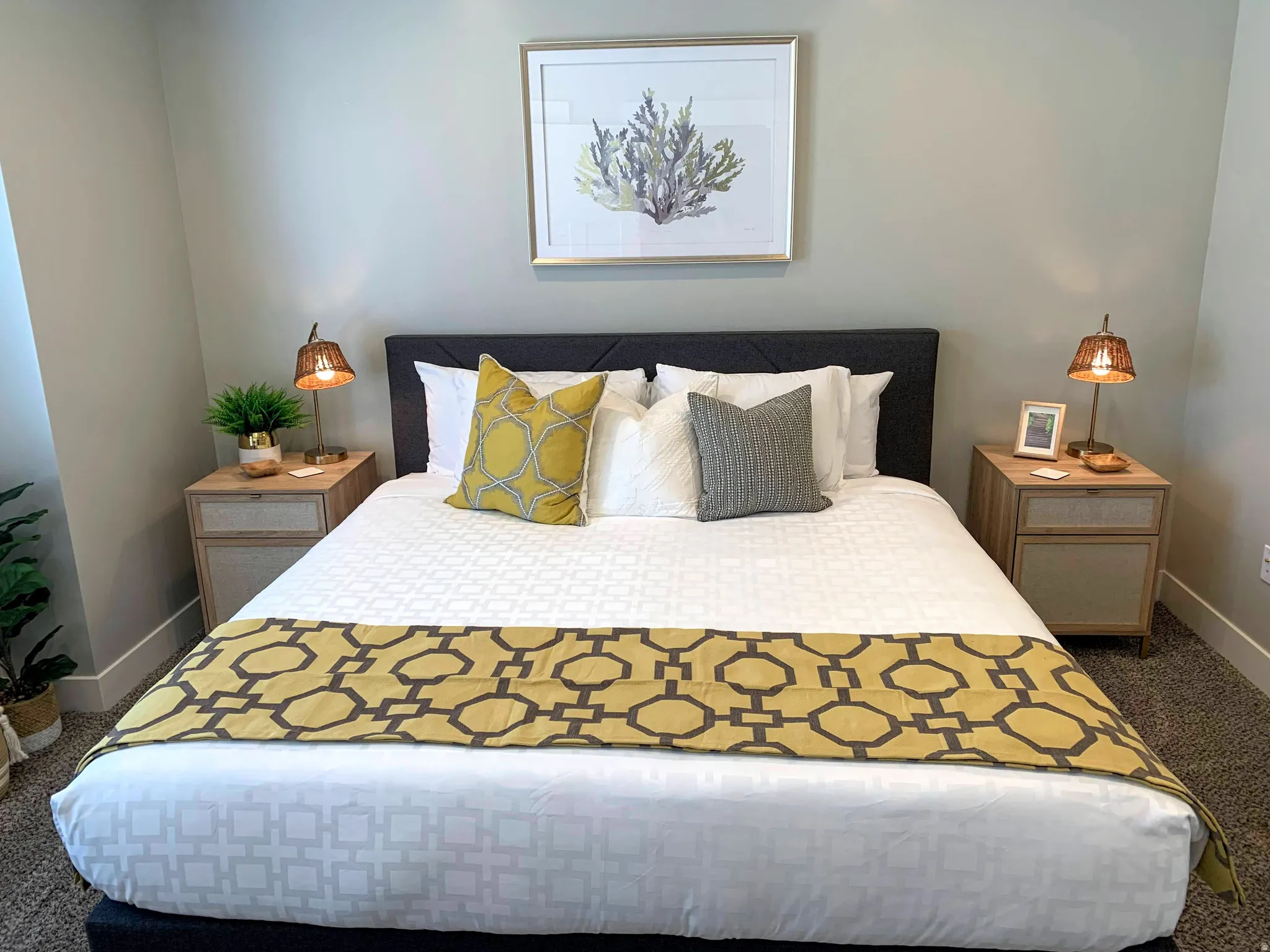 Neutral wall color with baseboard trim and textured carpeting