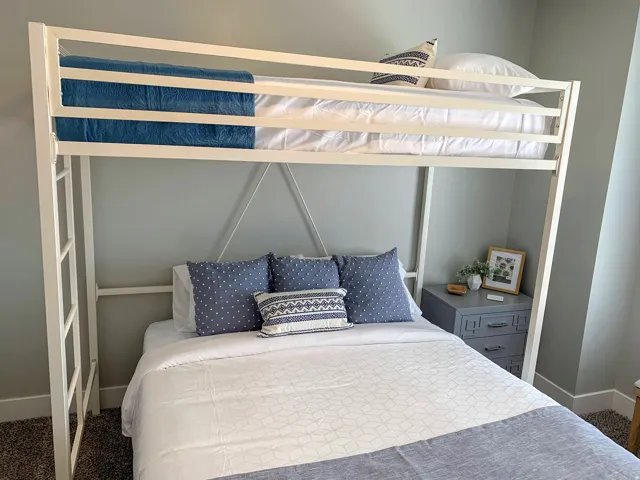 Built-in metal loft bed with an integrated side ladder and a lower bed platform