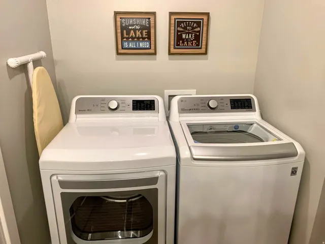 Dedicated laundry area featuring a white top-load washing machine and a white front-load dryer