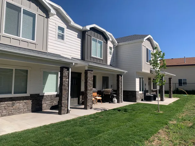 Multi-level exterior featuring white siding and dark stone veneer accents
