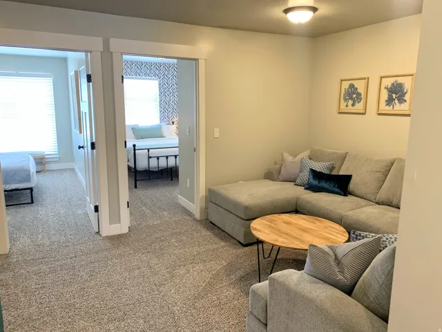 Carpeted room featuring a ceiling light fixture, two framed art pieces, and two open doorways