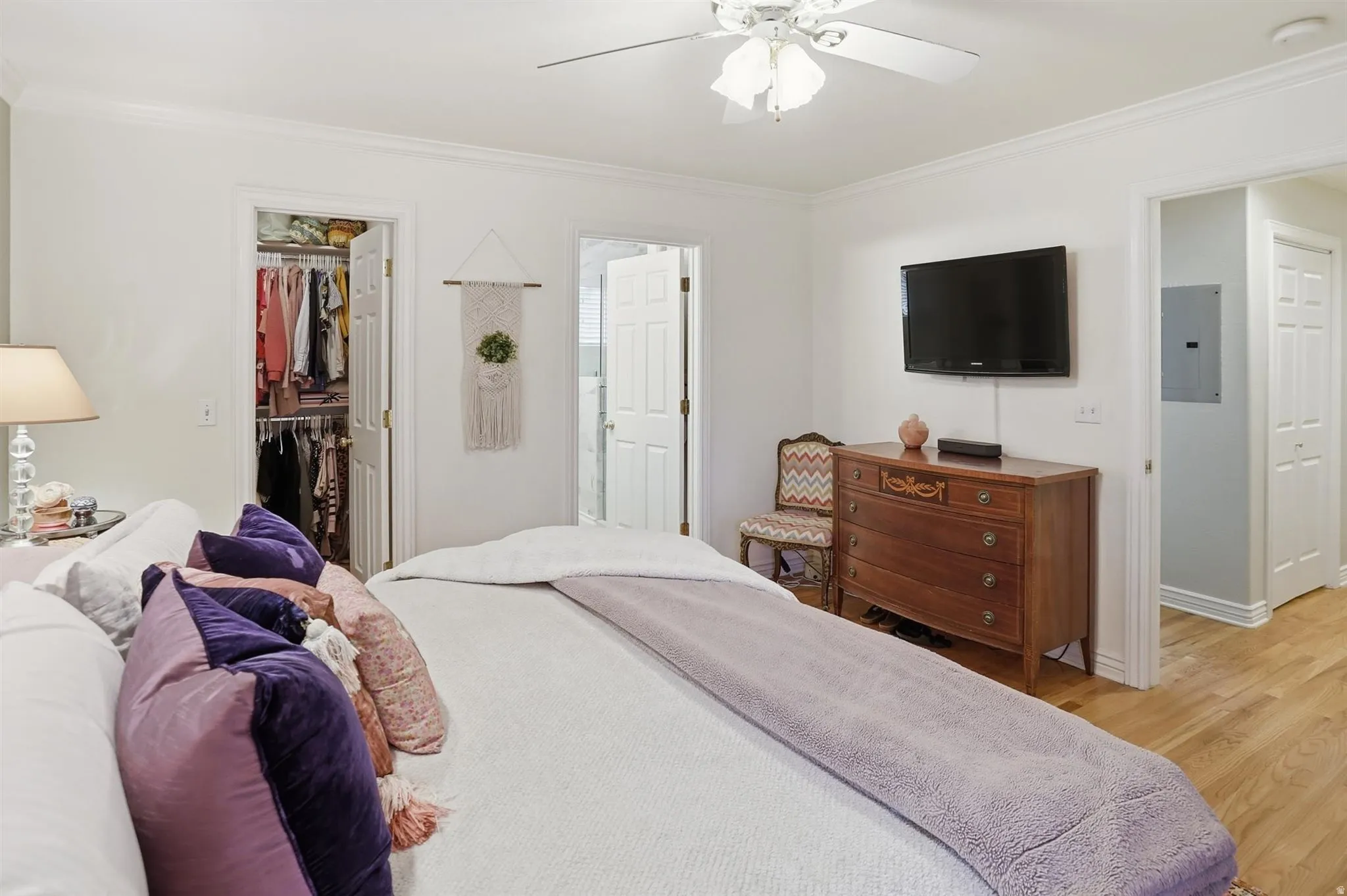 Hardwood-finish flooring featuring a white ceiling fan, crown molding, and white trim