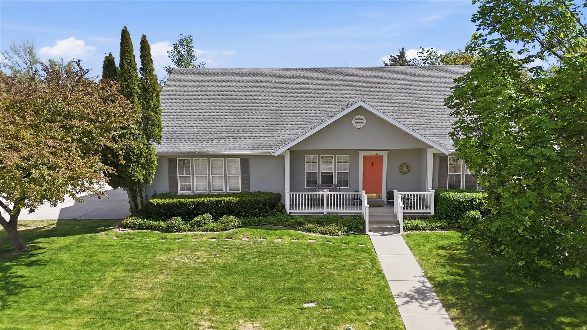 Rambler-style residence featuring a prominent gabled entrance with a vibrant pink front door