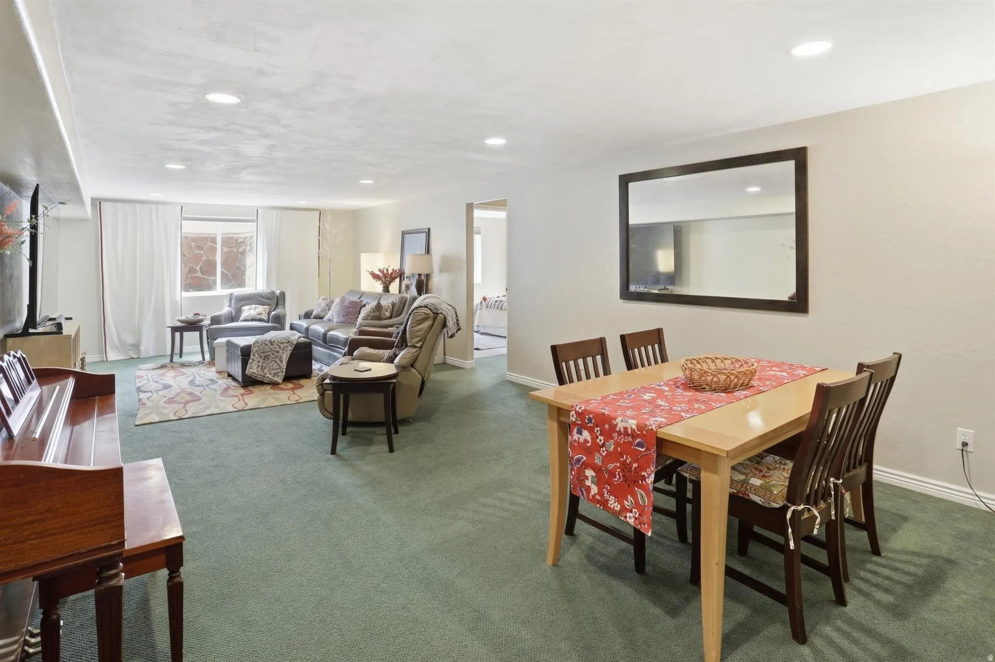 Open-concept living and dining areas featuring recessed lighting, light-toned wall paint, and green carpeting