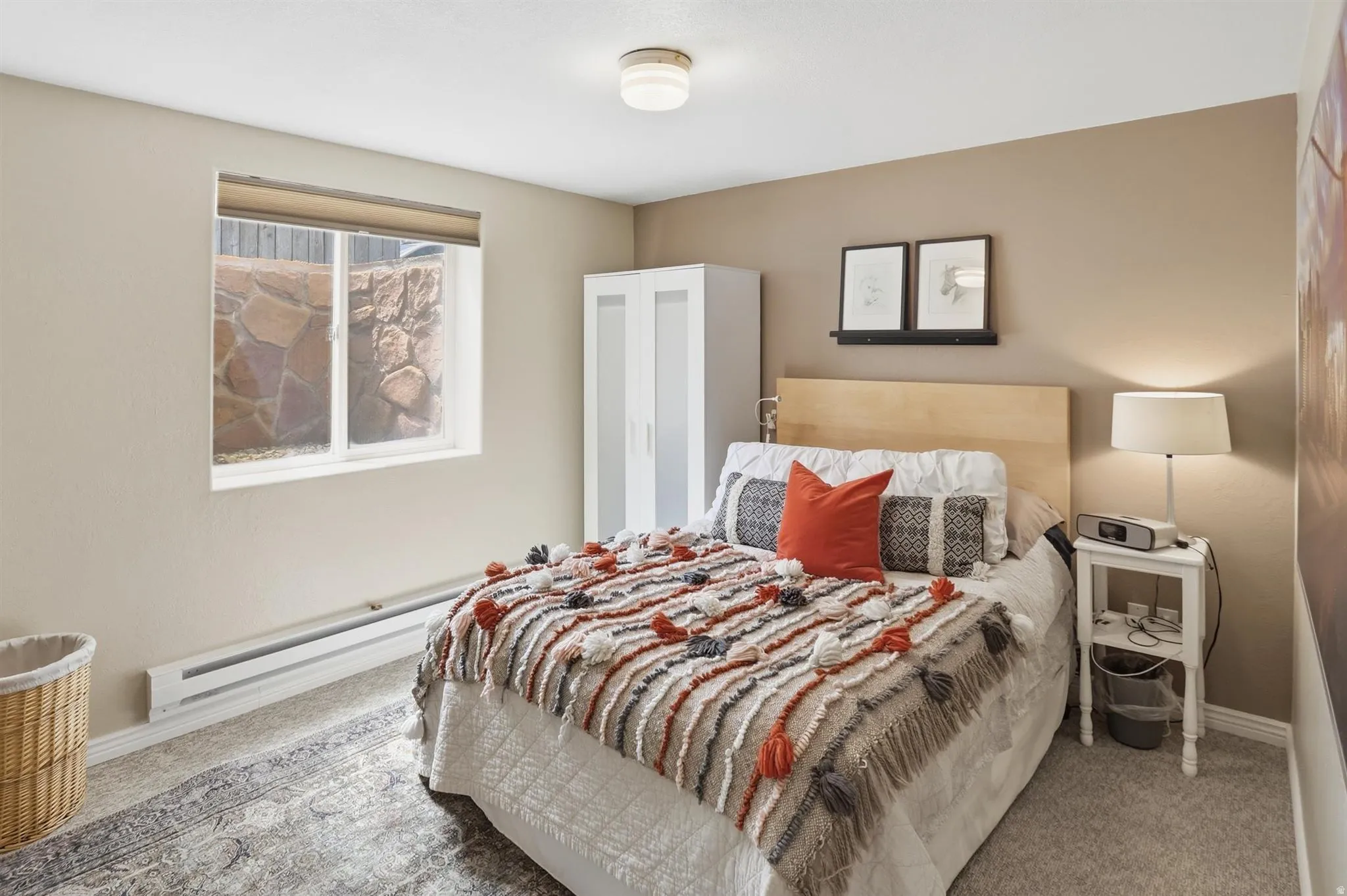Bedroom 4 Carpeted room with a double-pane window, light beige wall paint, and a baseboard heater