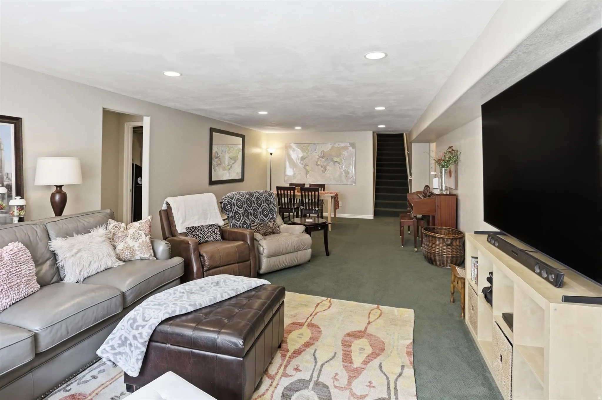 Versatile living area featuring recessed lighting, a neutral paint palette, and green carpeting