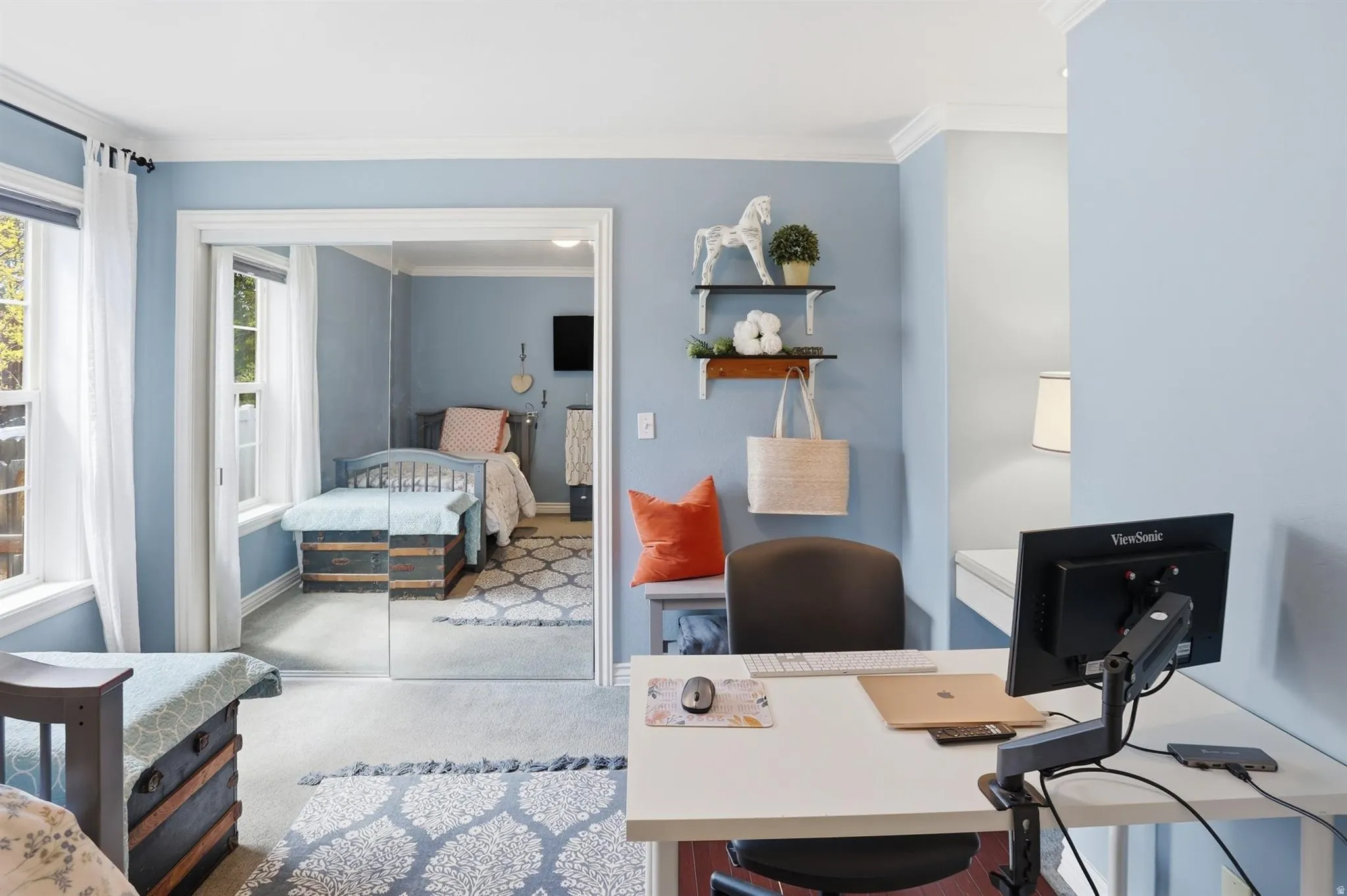 Bedroom 2 Bright interior space featuring a built-in desk, crown molding, and light blue walls