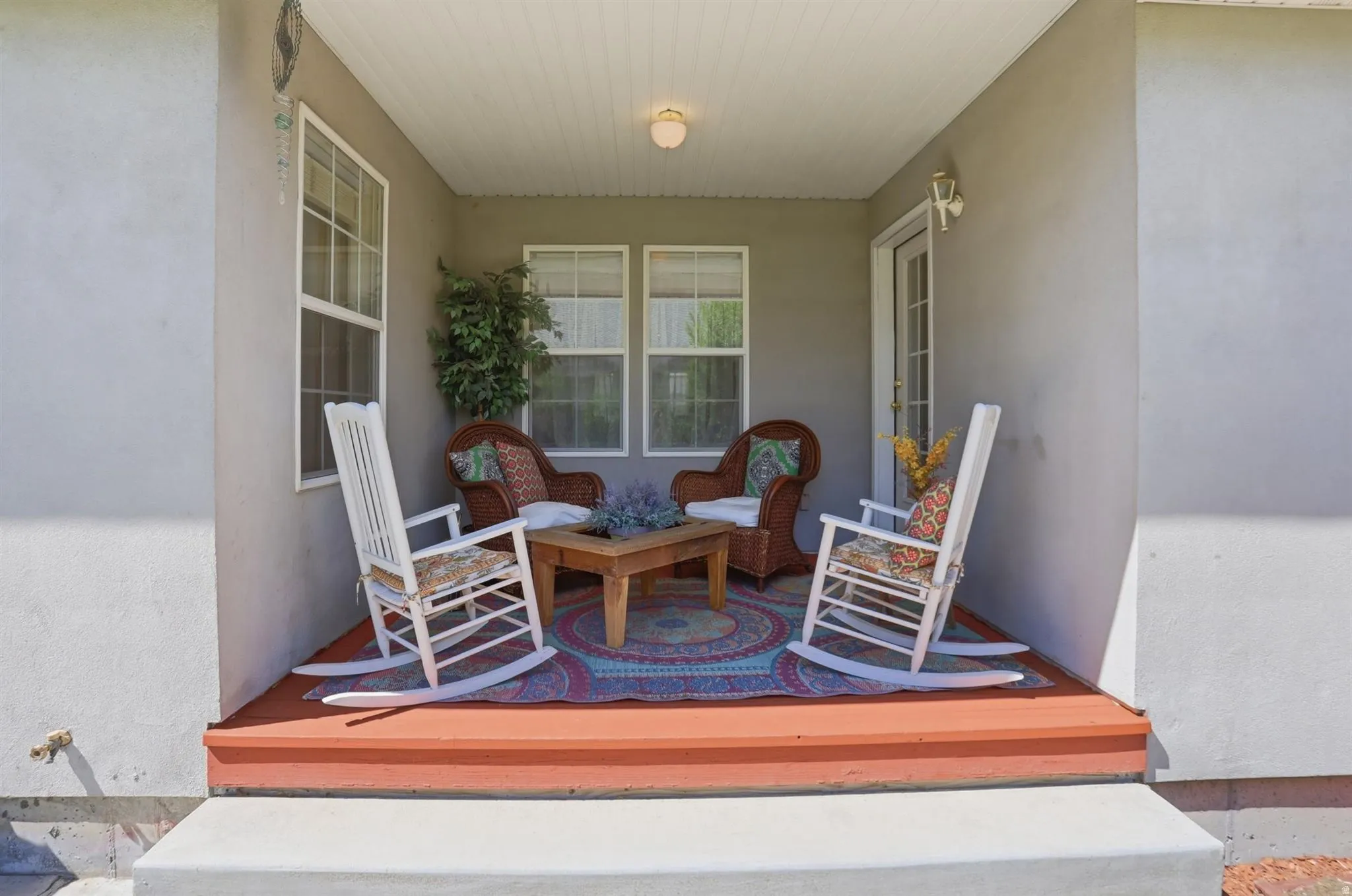 Covered front deck featuring a wood-finish floor, recessed lighting, and multiple windows