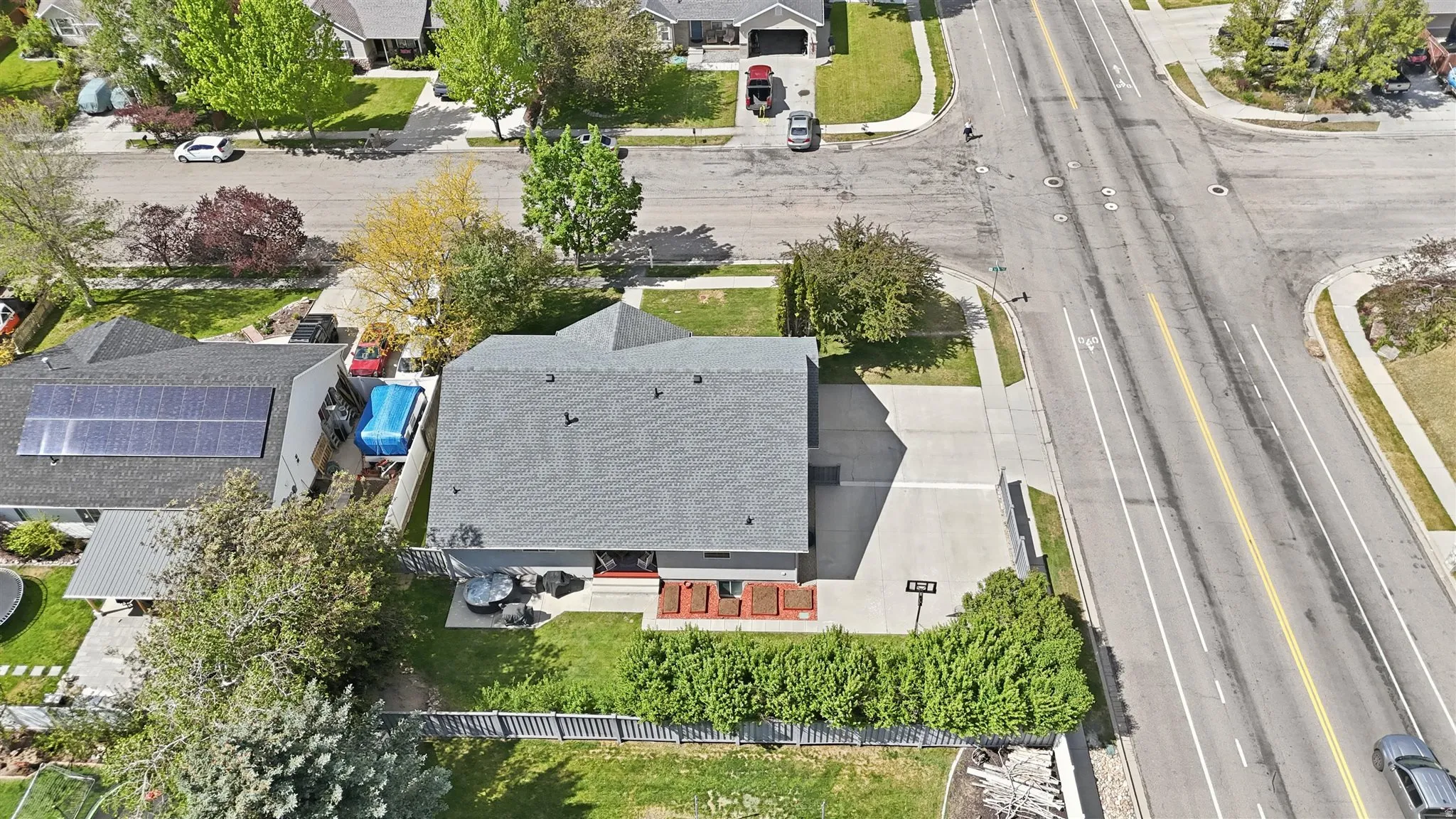 Aerial perspective showcasing a residential property with a shingle roof and a concrete driveway