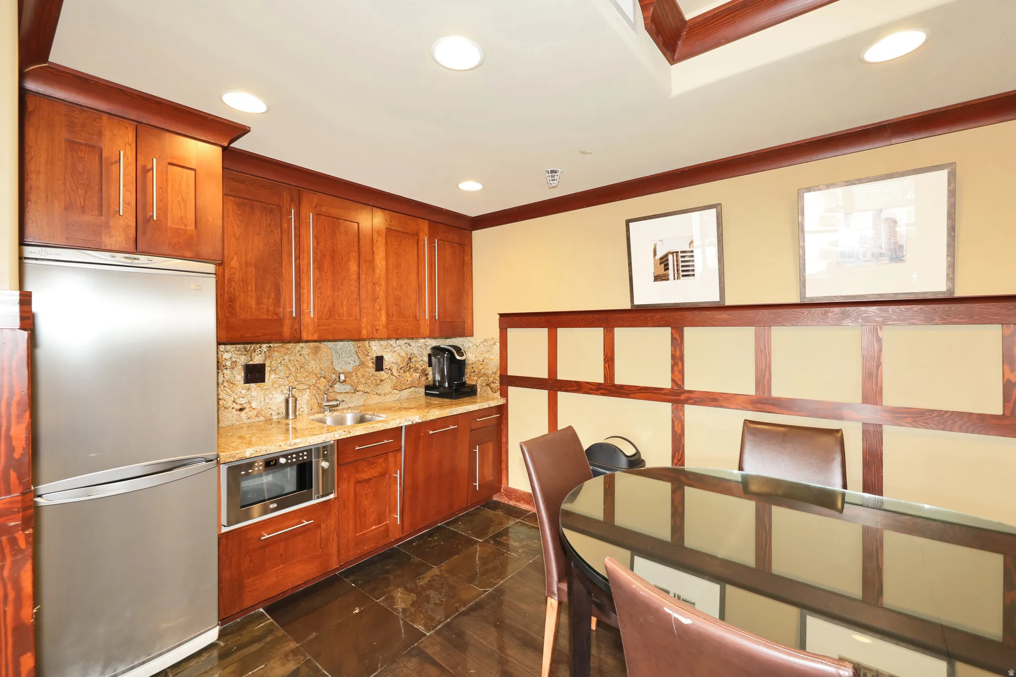 Built-in kitchenette featuring full-height cherry wood cabinetry, a stainless steel refrigerator, and a built-in microwave