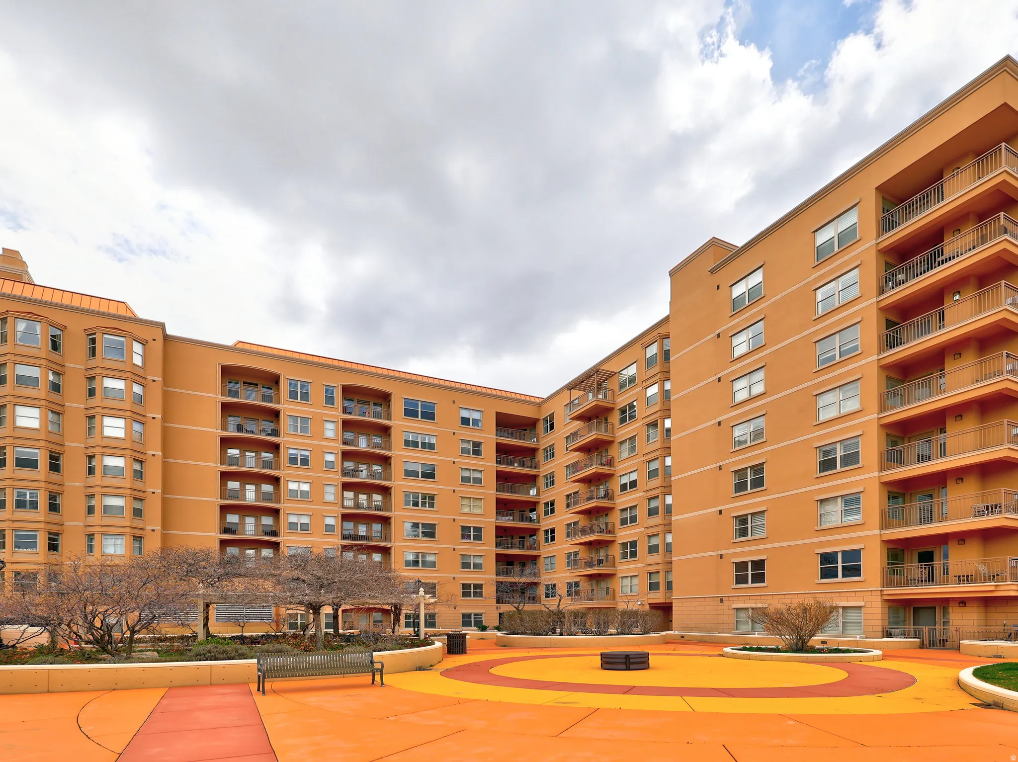 Multi-story building featuring a stucco exterior with multiple balconies and bay windows