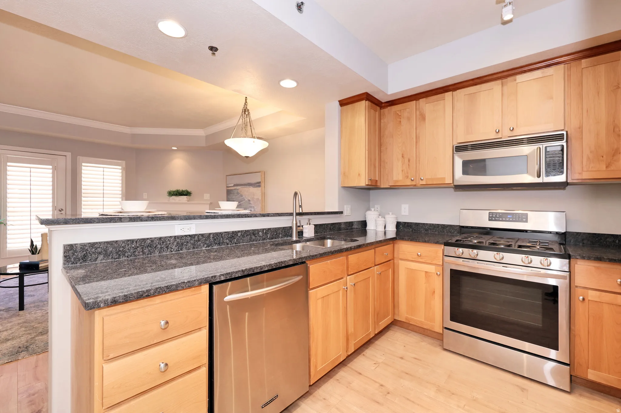 Kitchen featuring wood-finish flooring, granite countertops, and stainless steel appliances