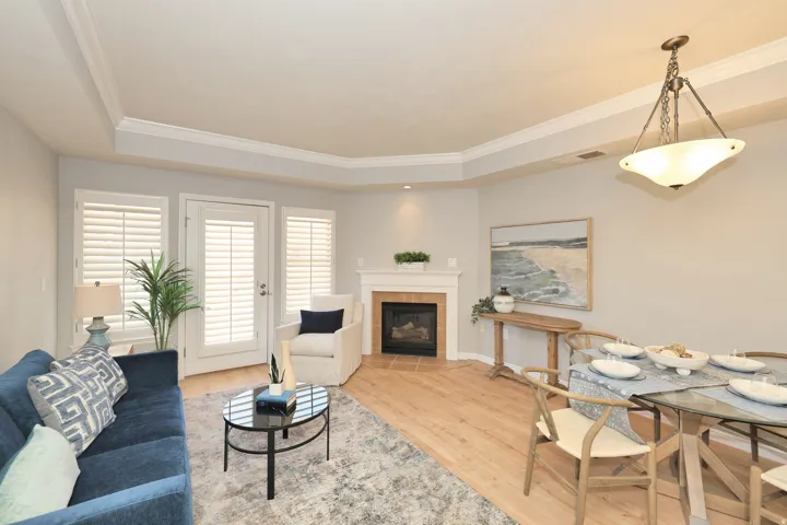 Welcome to your New Home! Open-concept living area with wood-finish flooring, crown molding, and a tray ceiling