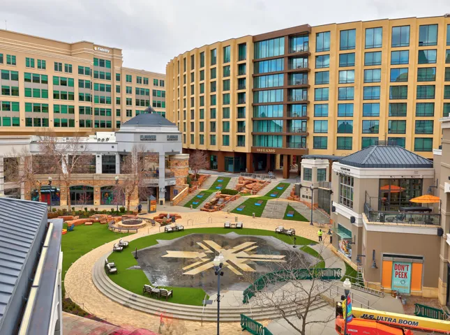 Landscaped courtyard featuring a central lawn area, decorative paving, and terraced green spaces