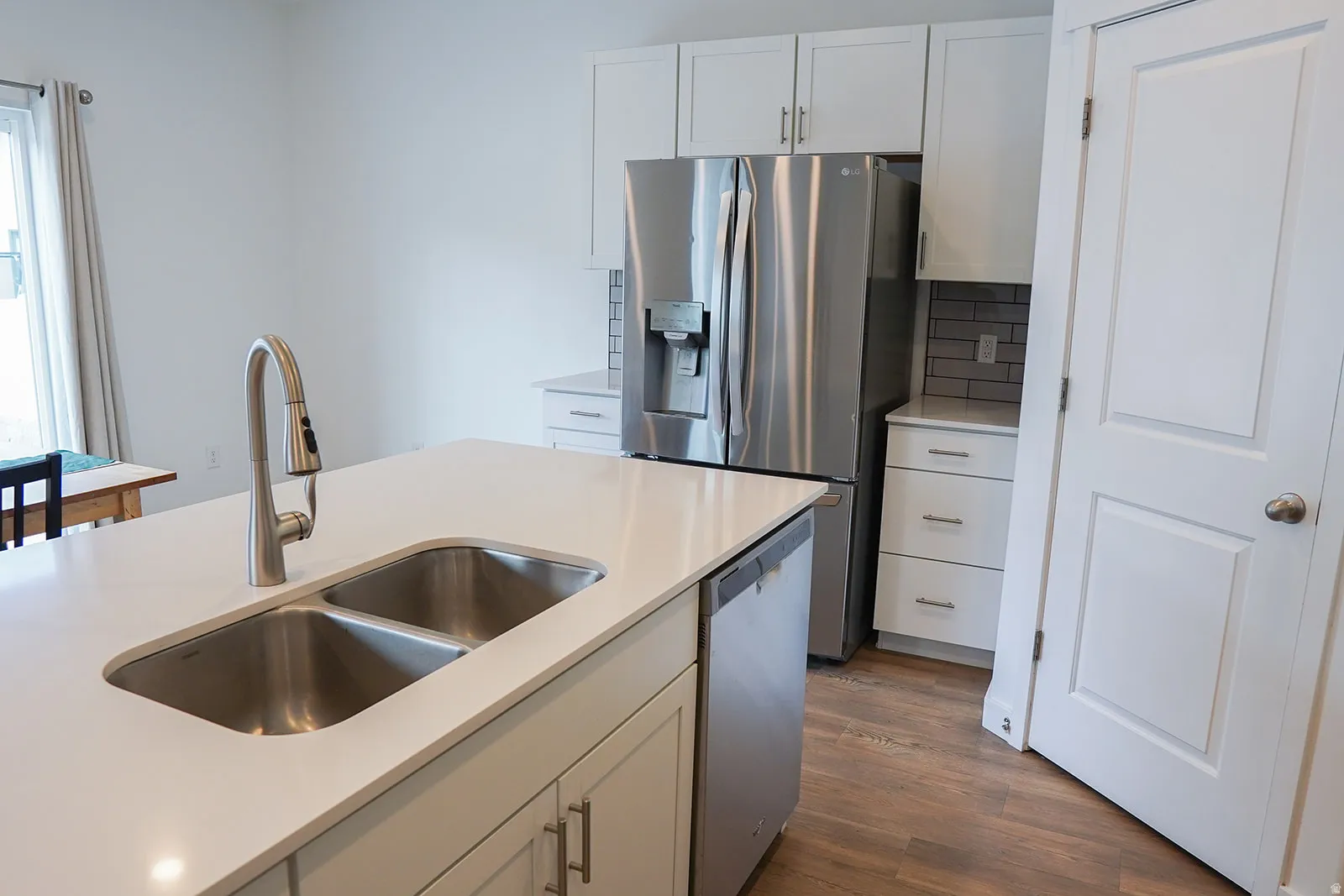 Kitchen island featuring a dual stainless steel sink and a gooseneck faucet