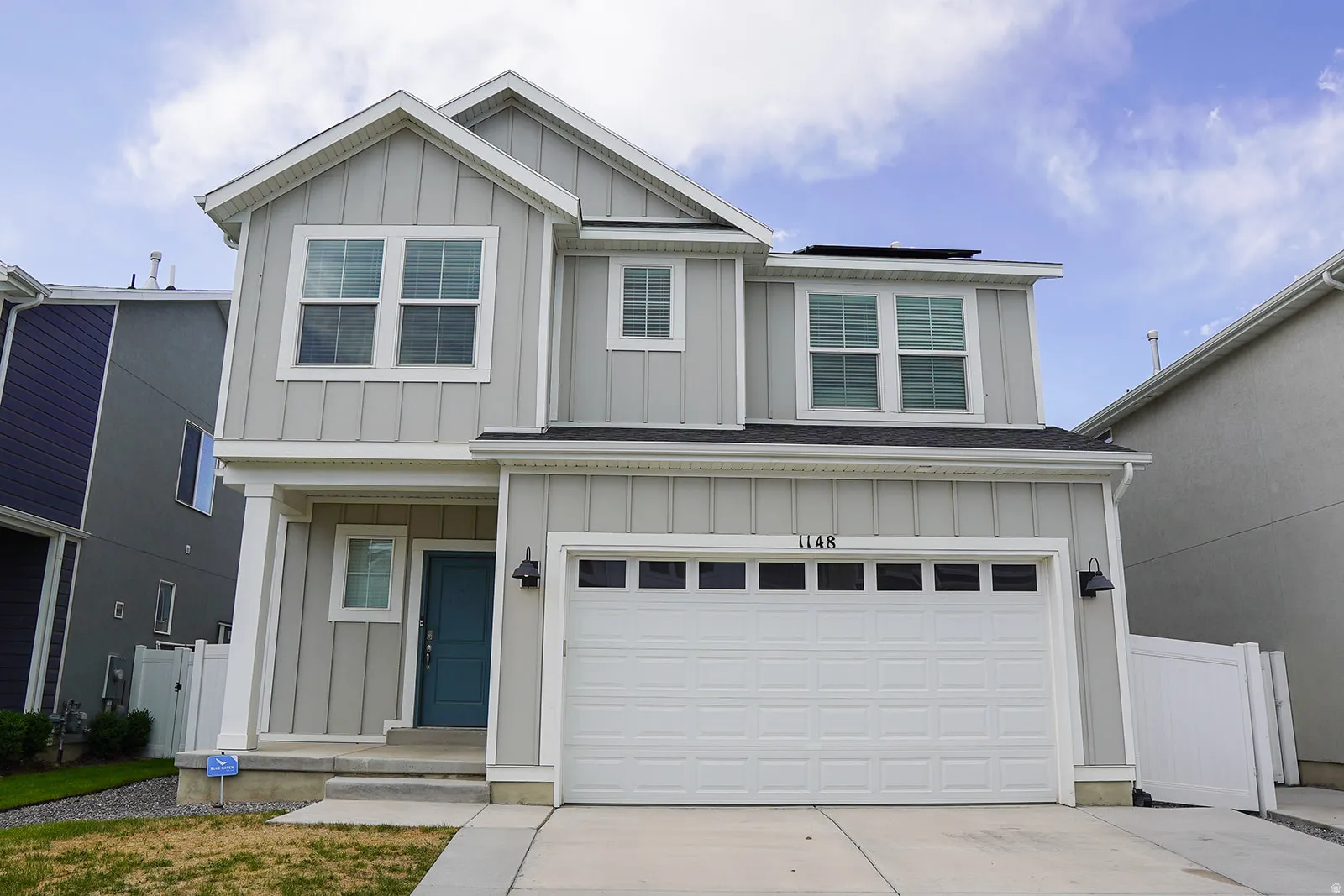 Two-story residence featuring light gray board-and-batten siding and white trim