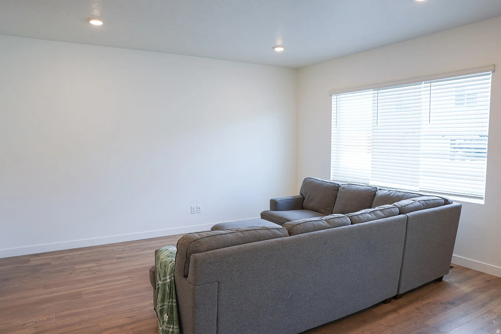 Living space featuring wood-finish flooring, recessed lighting, and ample natural light from multiple windows