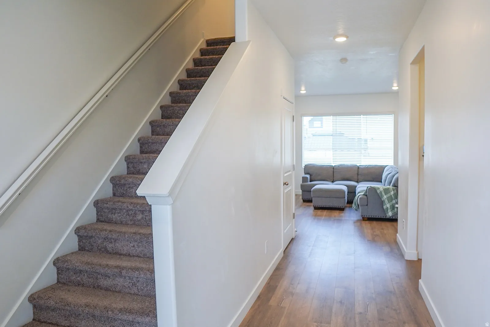 Carpeted staircase with white railings