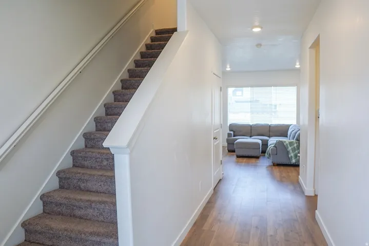Carpeted staircase with white railings