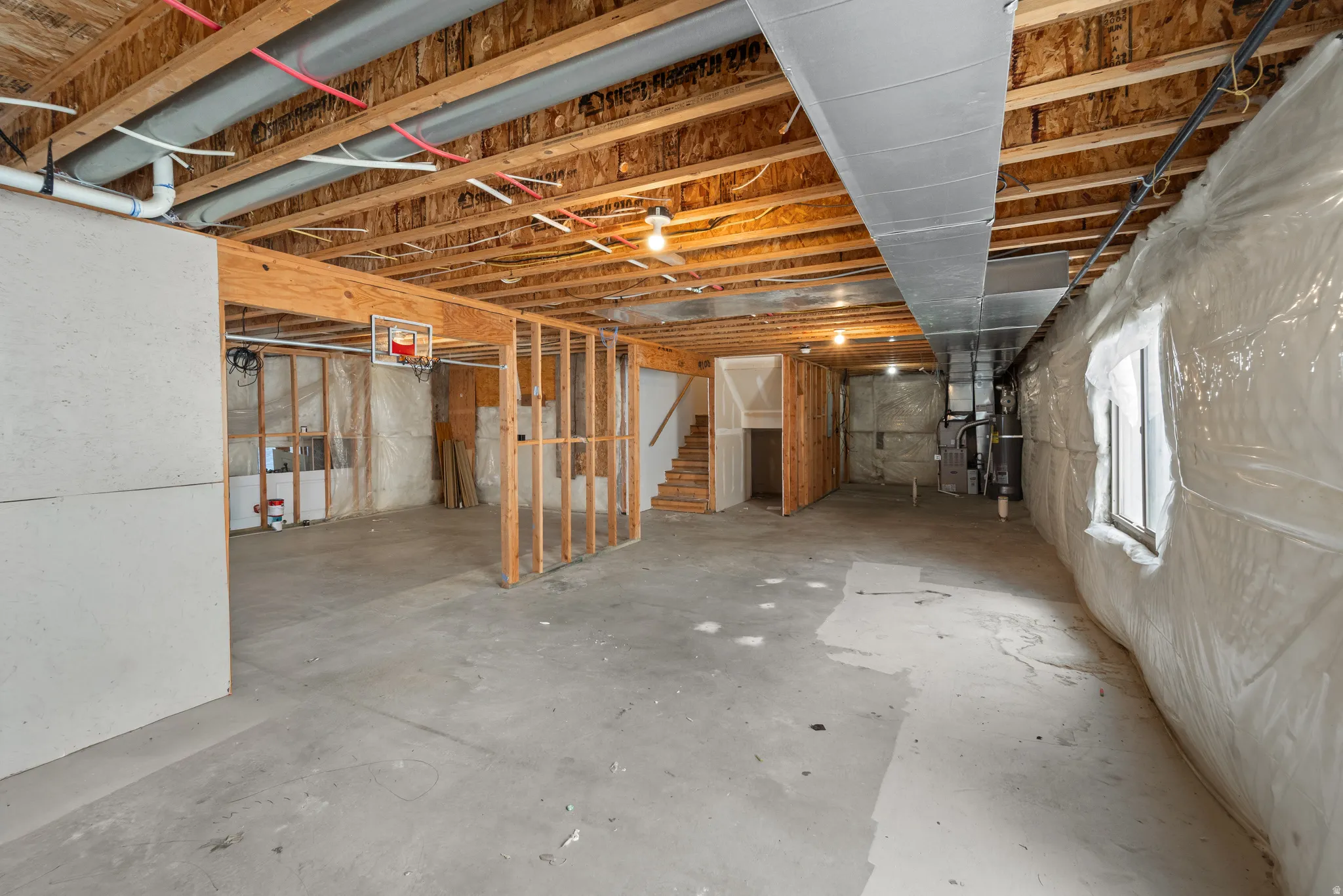 Unfinished basement with concrete flooring and exposed joists
