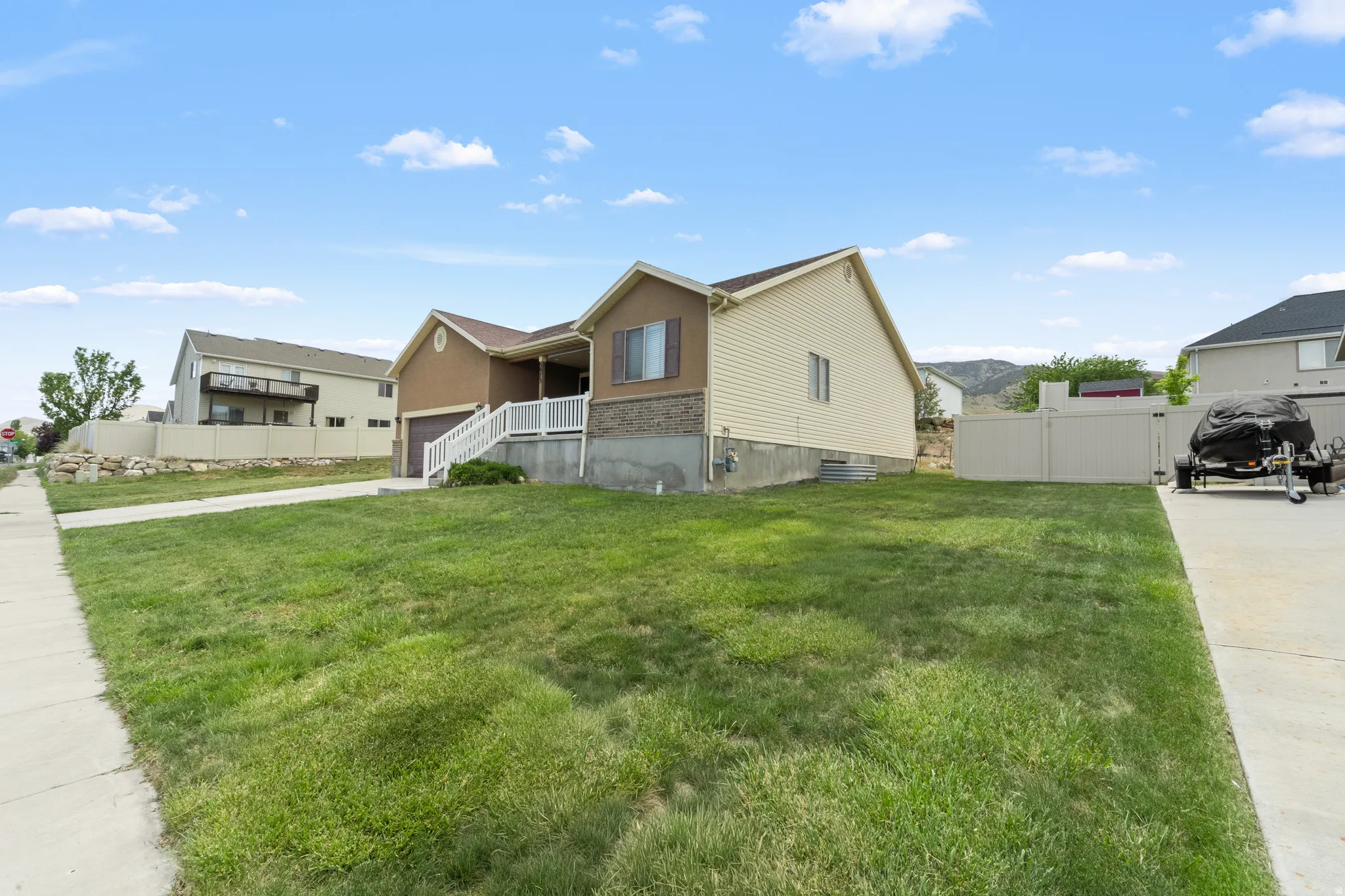 Split-level residence featuring a two-tone exterior, an attached garage, and a covered porch with white railings