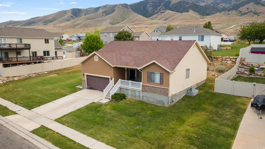 Ranch-style residence featuring a two-tone exterior with tan stucco and light beige siding, a dark brown shingle roof, and an attached two-car garage