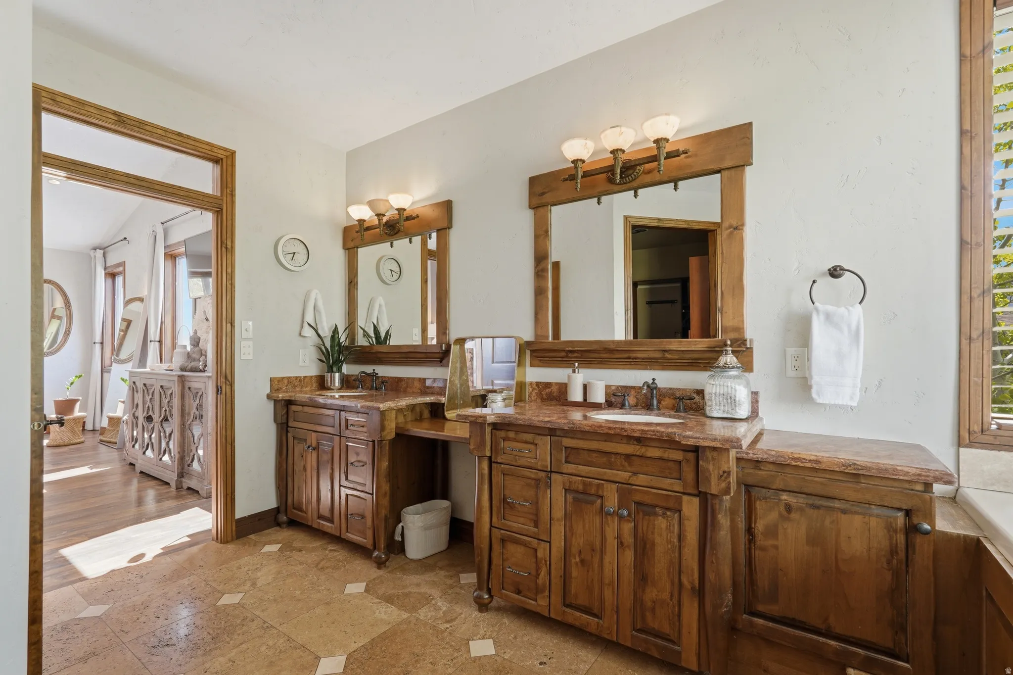 Double vanity featuring wood cabinetry, stone countertops, and integrated sinks
