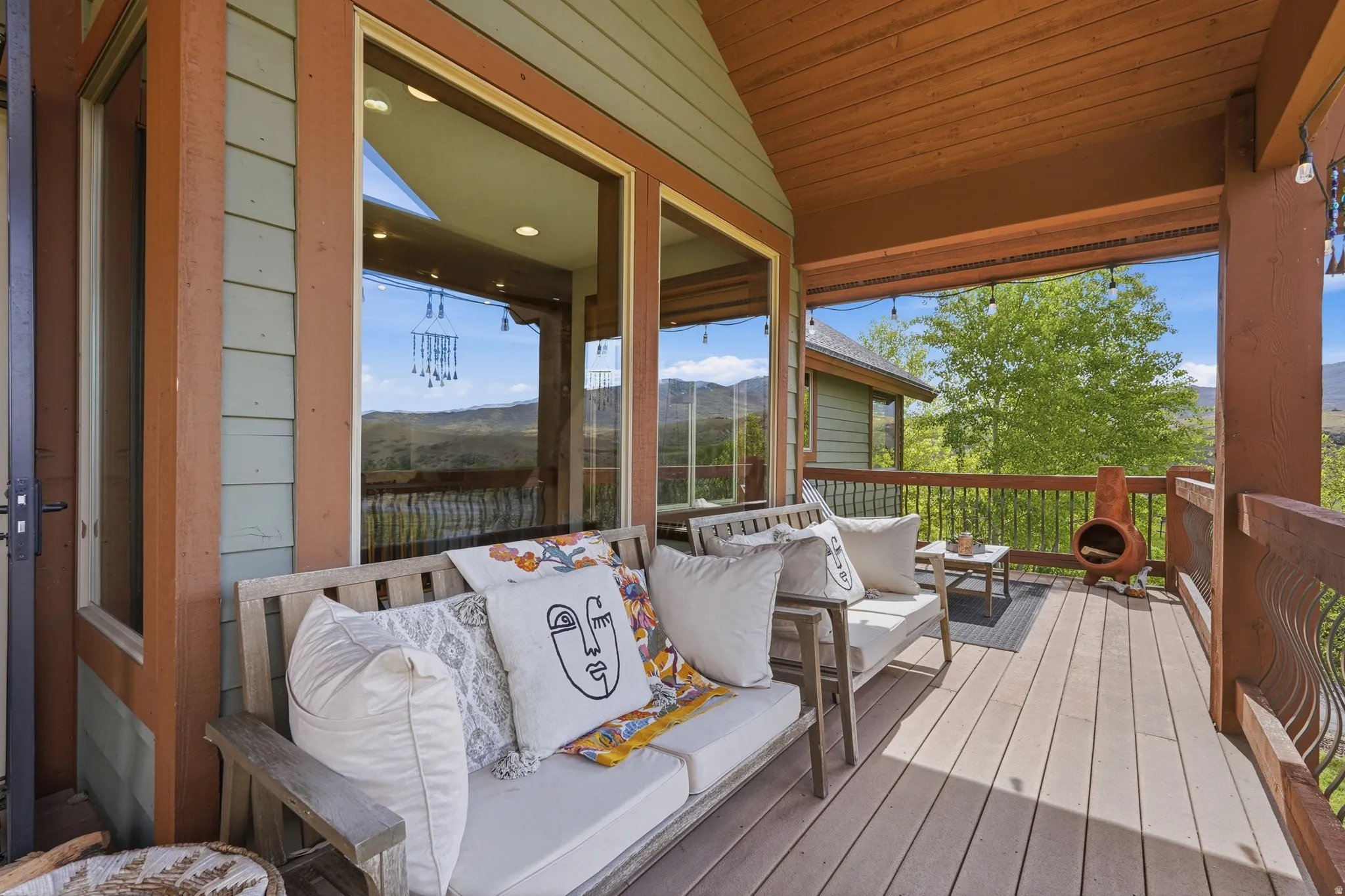 Expansive covered deck featuring wood-finish flooring, a wood-paneled ceiling, and large windows
