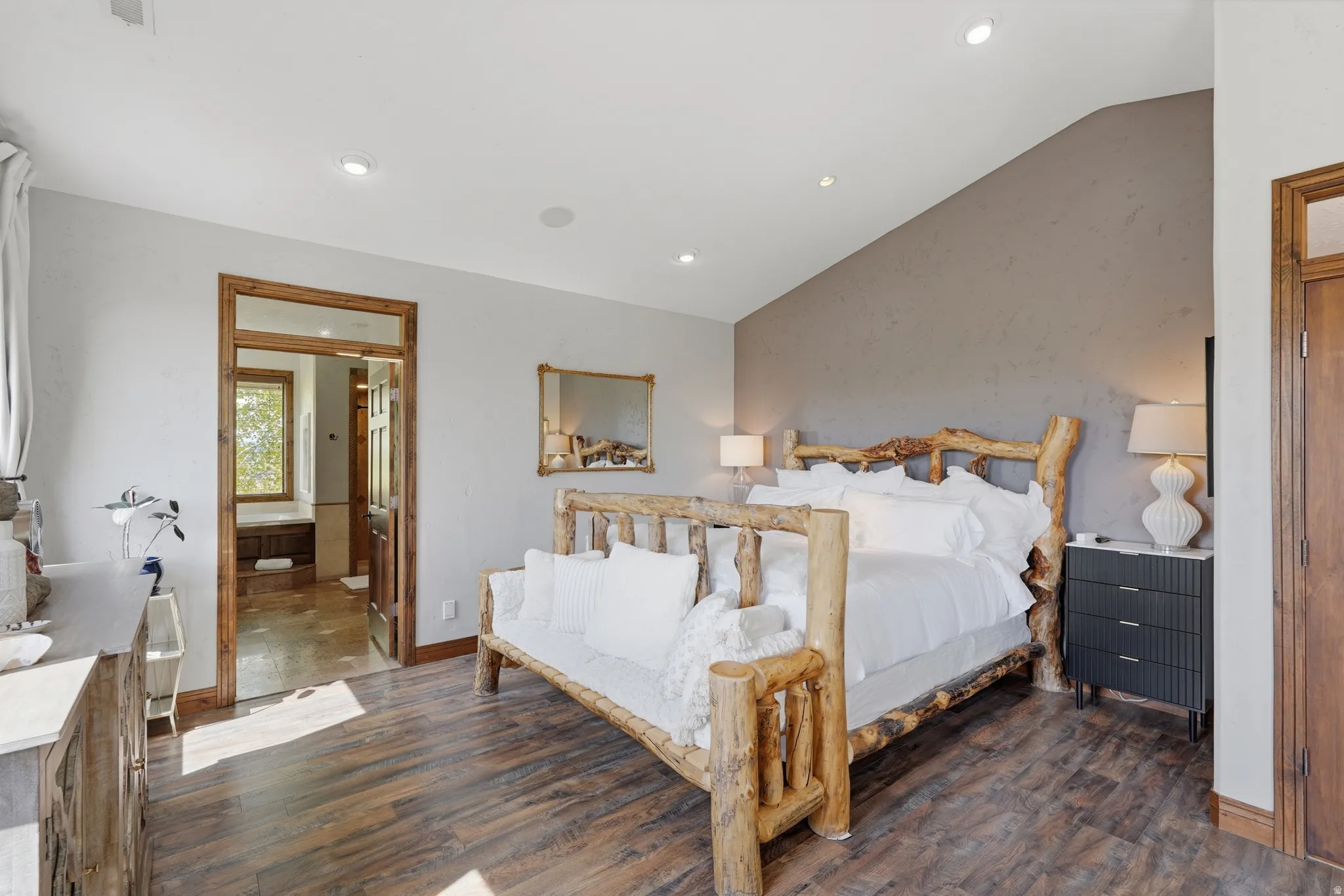 Spacious room with wood-finish flooring, recessed lighting, and a vaulted ceiling accent wall