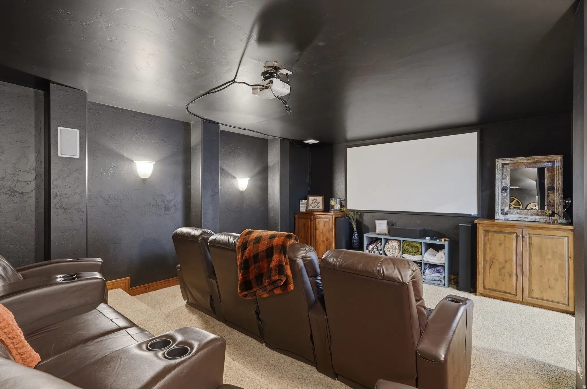 Dedicated entertainment room featuring tiered seating and a built-in projection screen